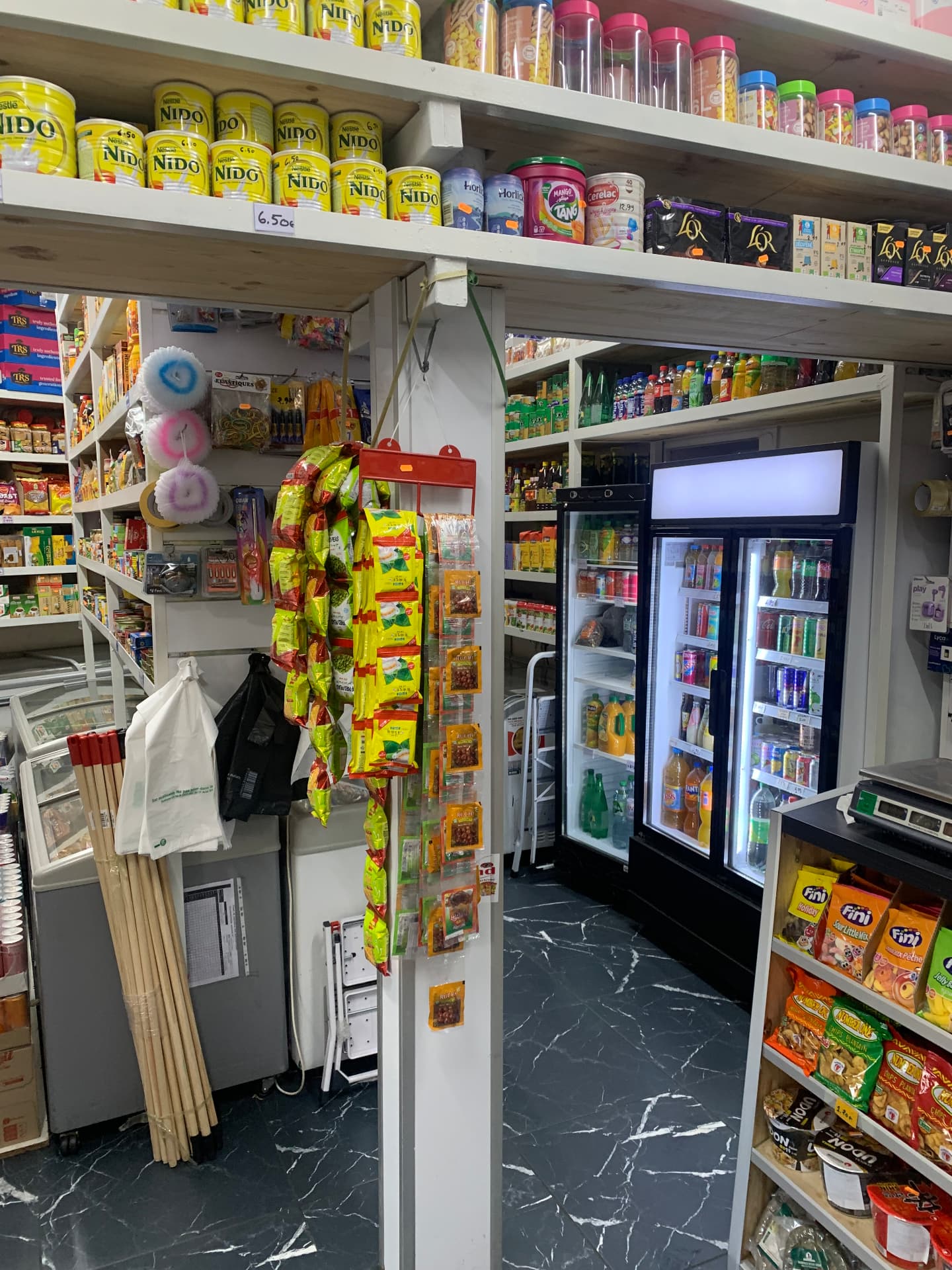 Allée intérieure de l'épicerie Shukriya Alimentation avec vitrines réfrigérées de boissons fraîches
